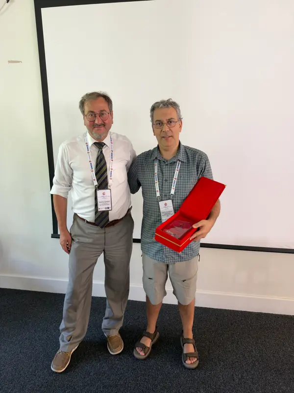 Two participants holding an award plaque.